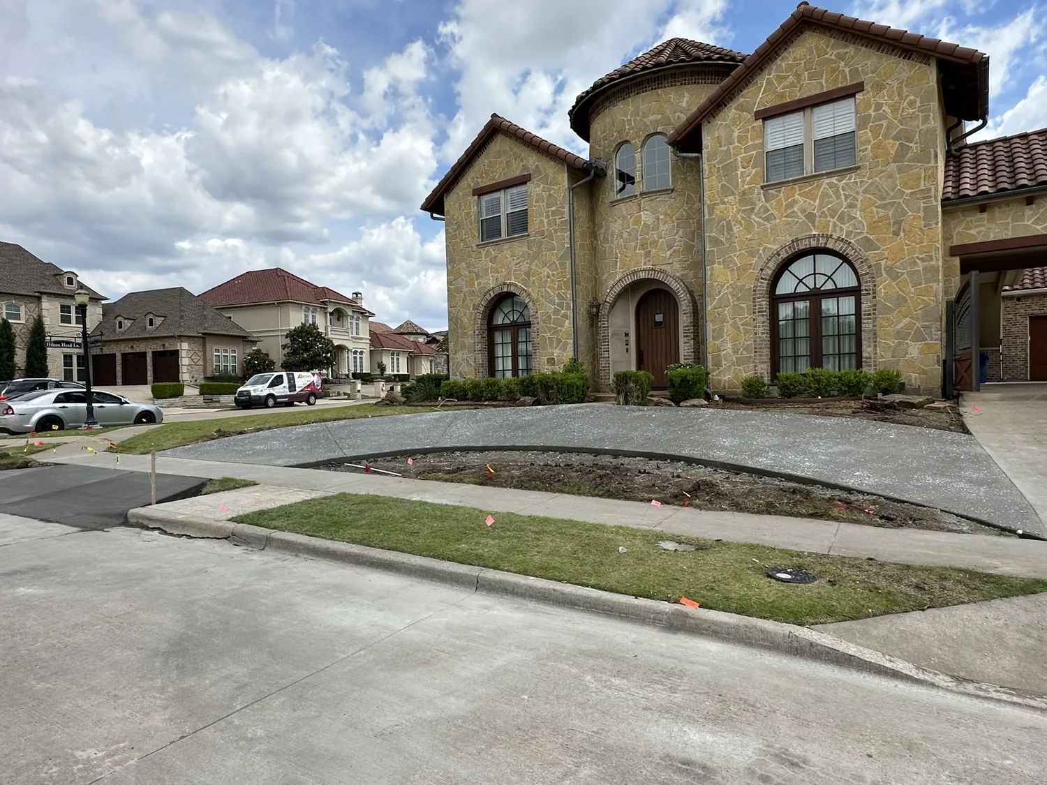 Wide finished residential concrete driveway and walkway at an upscale two-story home by Lucky's Concrete
